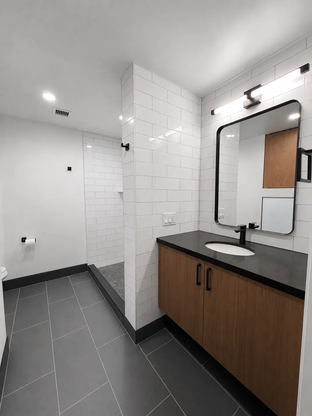 Studio bathroom with a warm, dark finish palette at The Ranstead